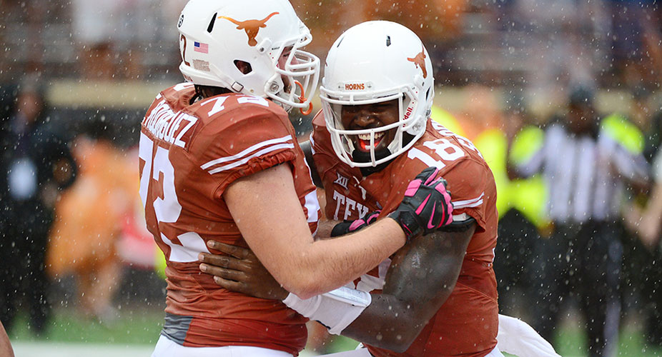 Two UT Football players smiling and excited after a play against K State