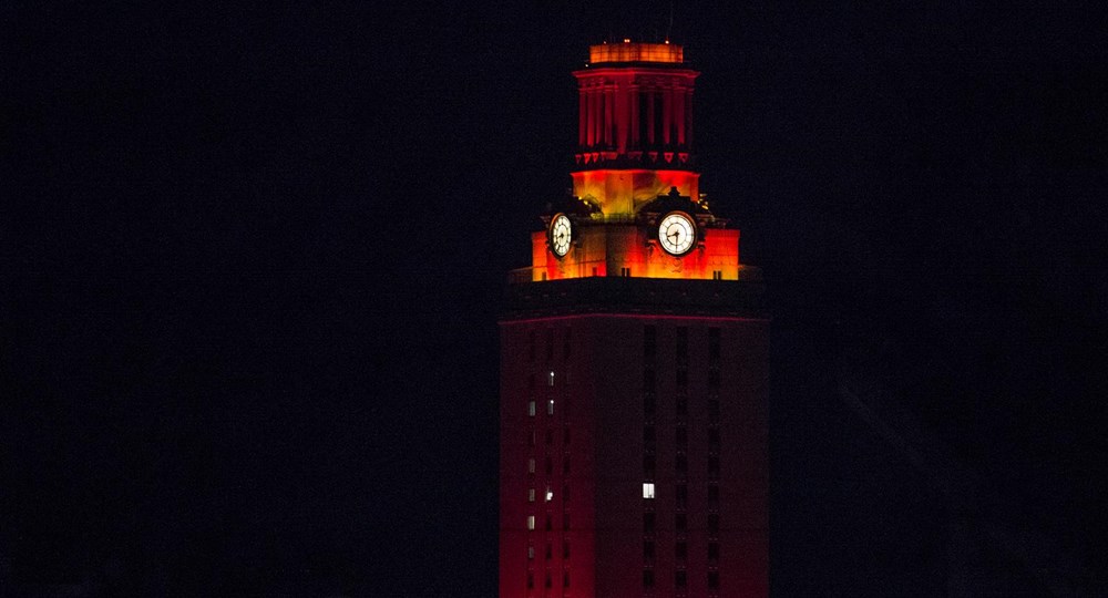 UT Tower glowing orange at the top and dark below