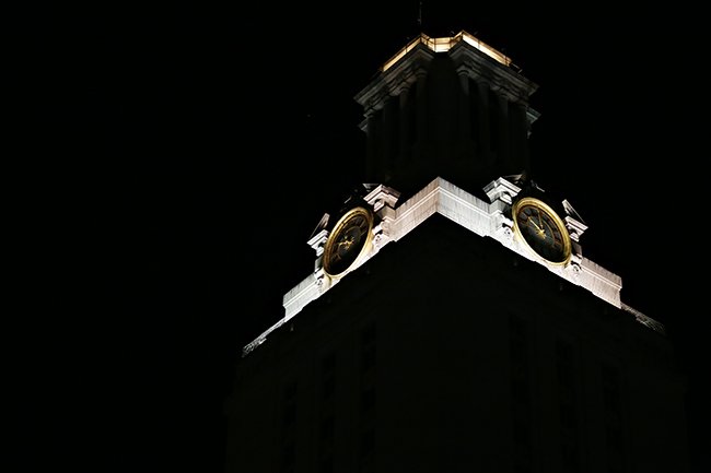 Top of the UT Tower pictured as darkened except the clock area which is illuminated white