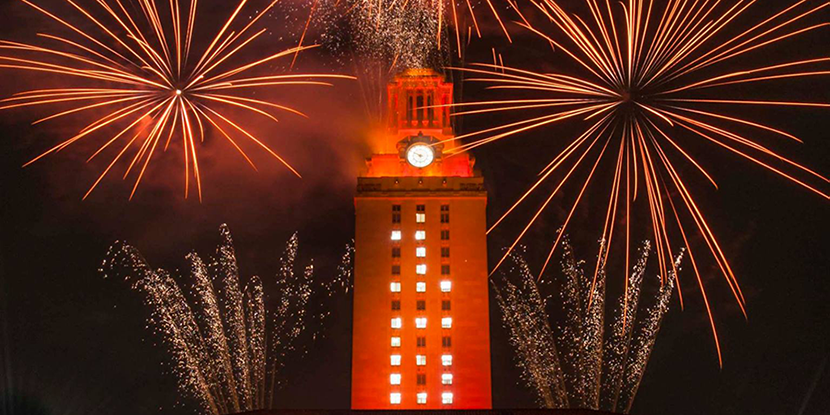 UT Tower displayed with the number 16 and lit orange with fireworks displayed in the background
