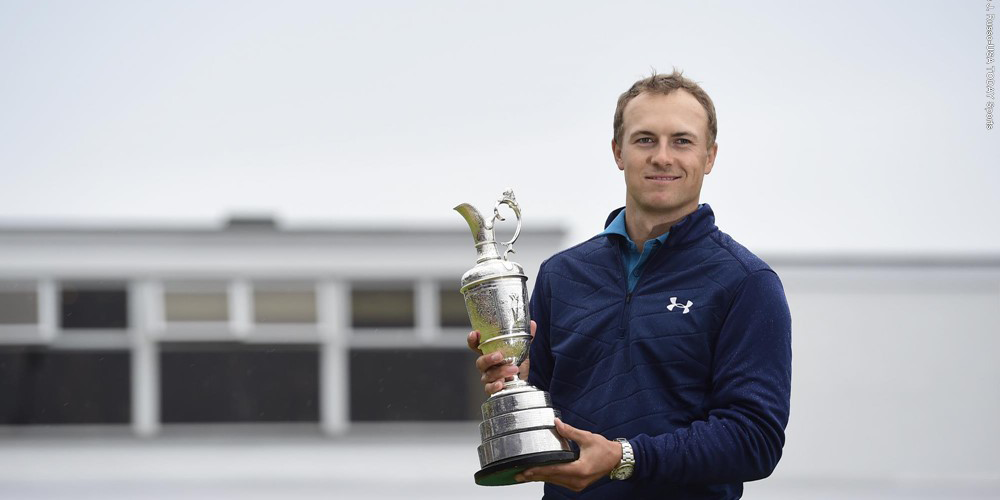 Jordan Spieth pictured holding a trophy facing forward and smiling