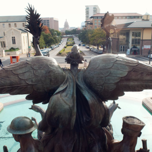 Image of Littlefield fountain sculpture looking south tower the Texas capitol building in the distance.
