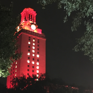 The UT Tower shines with burnt orange lights and the number “17” displayed on its sides.