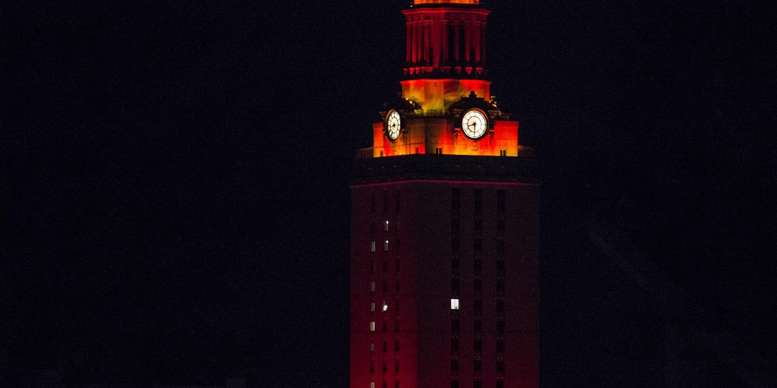UT Tower lit with burnt orange lighting at night. 