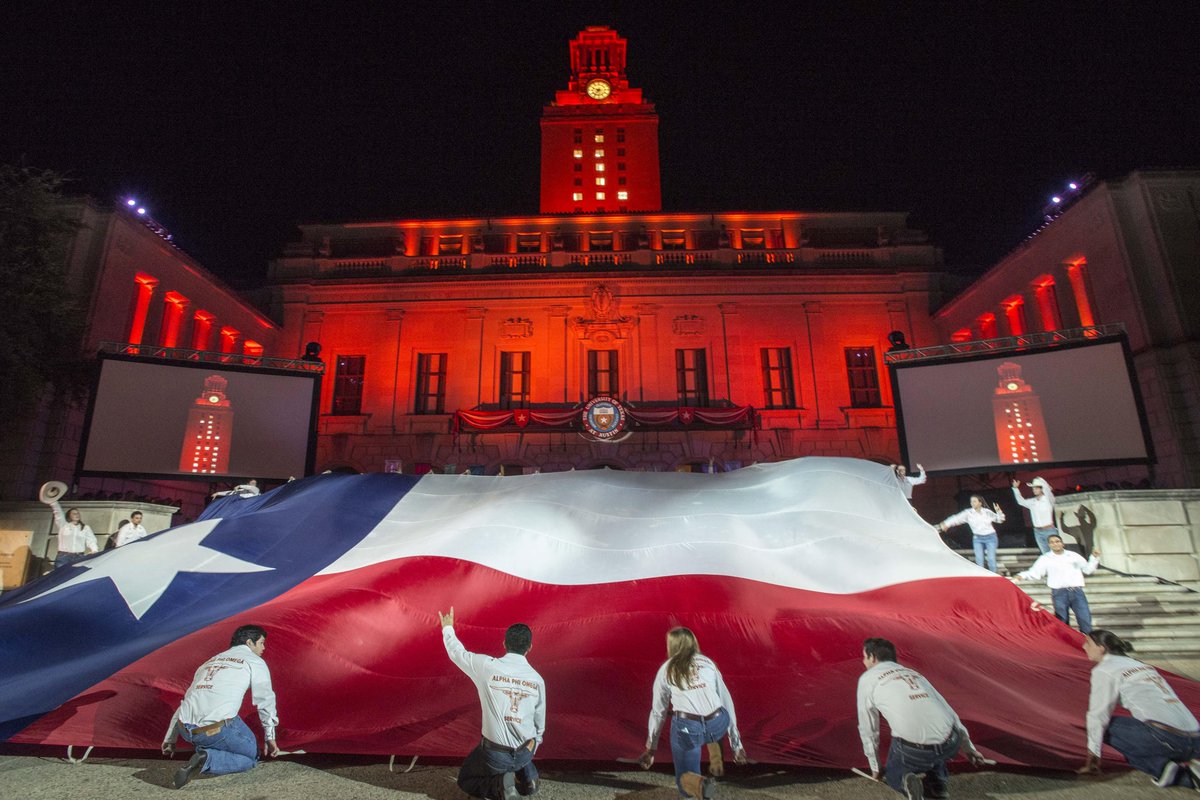 UT Students with the Texas flag in front of UT Tower. 