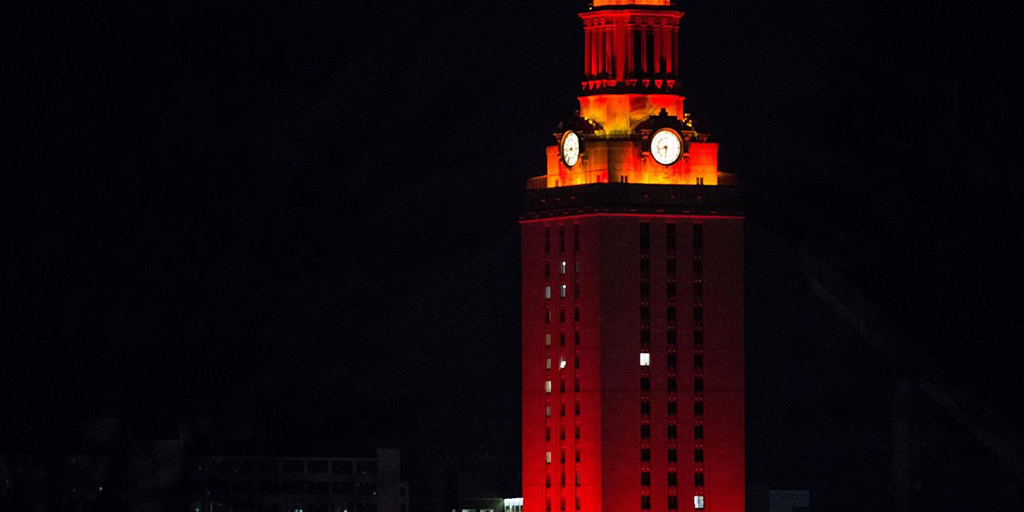 UT Tower lit burnt orange in the night sky