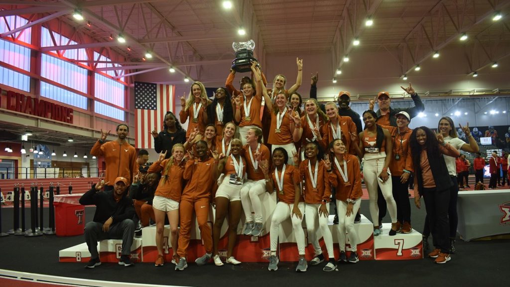 UT Women's track and field team holding the Big 12 indoor championship trophy.