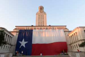 A giant Texas flag hangs in front of the UT Tower