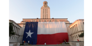 A giant Texas flag in front of the UT Tower