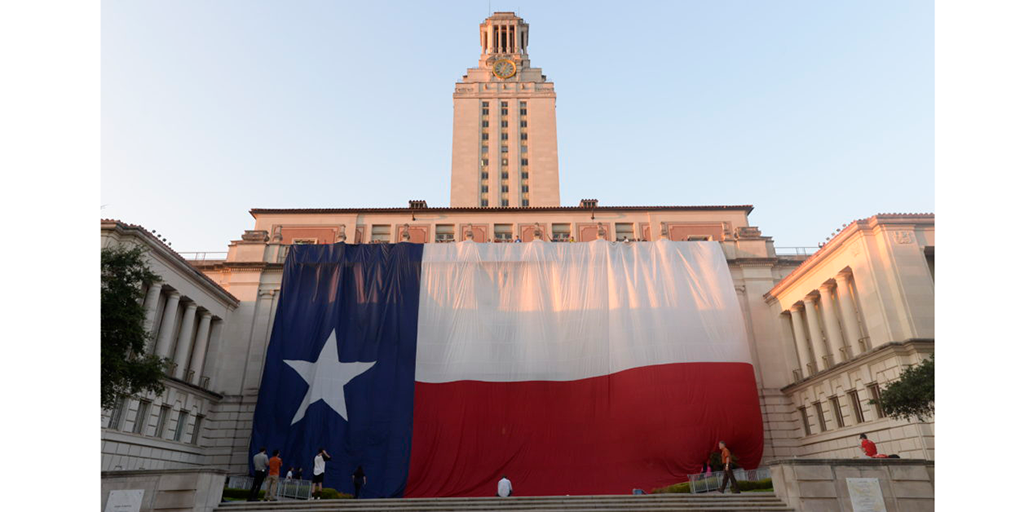 A giant Texas flag in front of the UT Tower