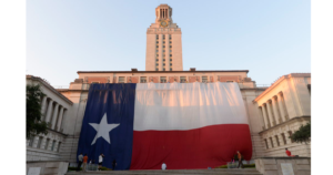 A giant Texas flag hangs in front of the UT Tower