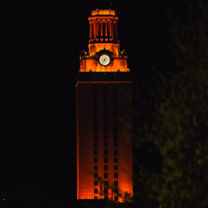 The UT Tower shines with burnt orange lights at night.