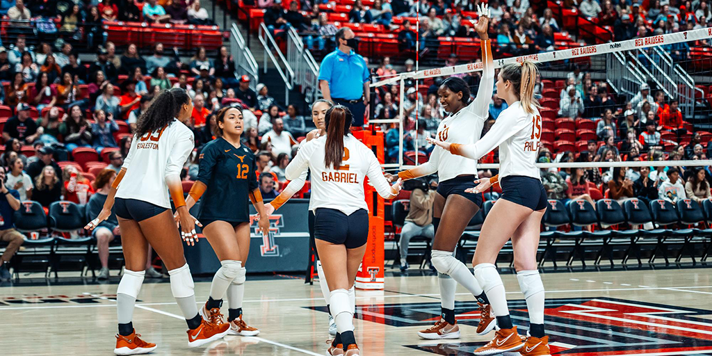 Texas Volleyball players celebrate on the court.