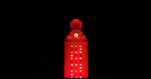 The UT Tower shines with burnt orange lights and the number “22” displayed on its sides.