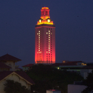 The UT Tower shines with burnt orange lights and the number 1 in the windows.