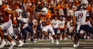 A photo of a Texas football player carrying the ball in a game versus UTSA