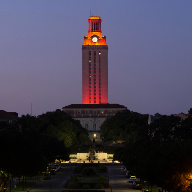The U.T. Tower shines with burnt orange lights at dusk.