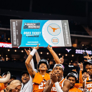 A Texas men's basketball student athletes holds up a celebratory sign