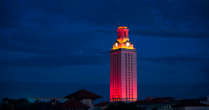 The U.T. Tower shines with burnt orange lights at night.