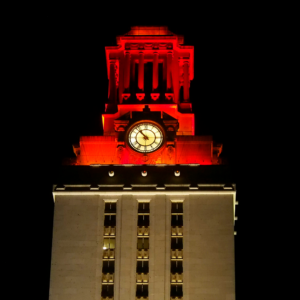 The top of the U.T. Tower shines with burnt orange lights