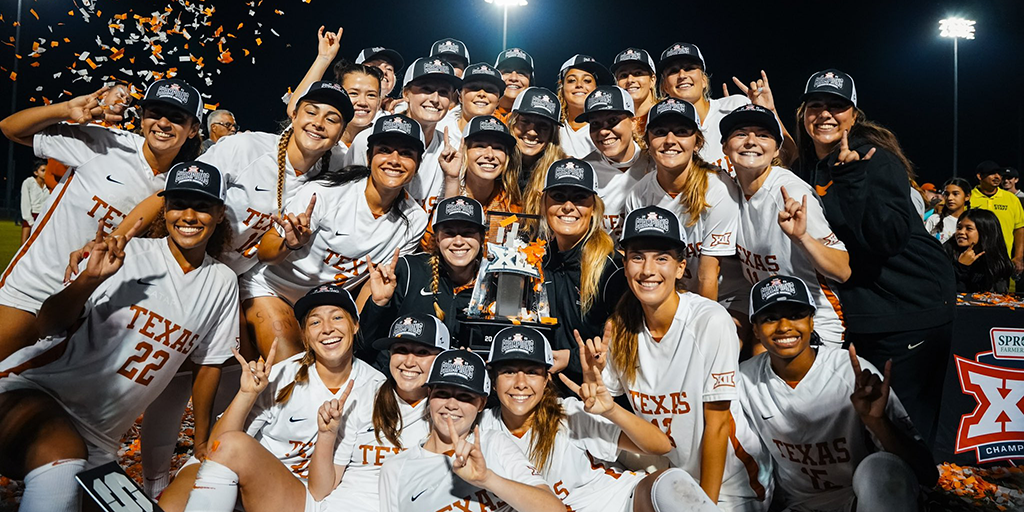 Members of the Texas Soccer team pose for a celebratory group photo with the Big 12 Conference trophy. 