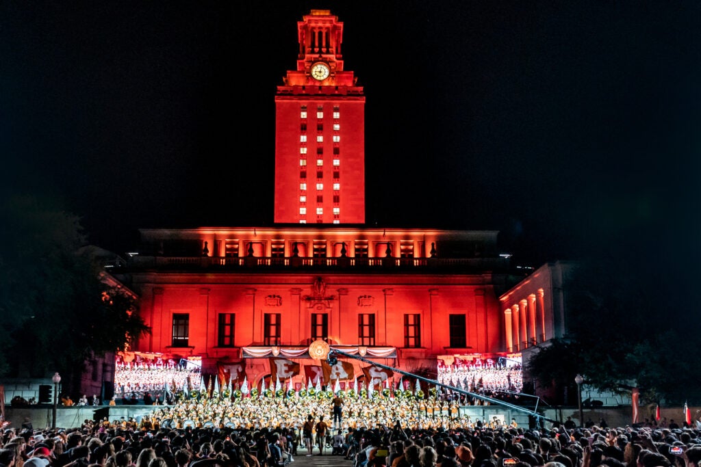 The University of Texas at Austin Tower is lit by burnt orange lights with 26 shining in the windows.